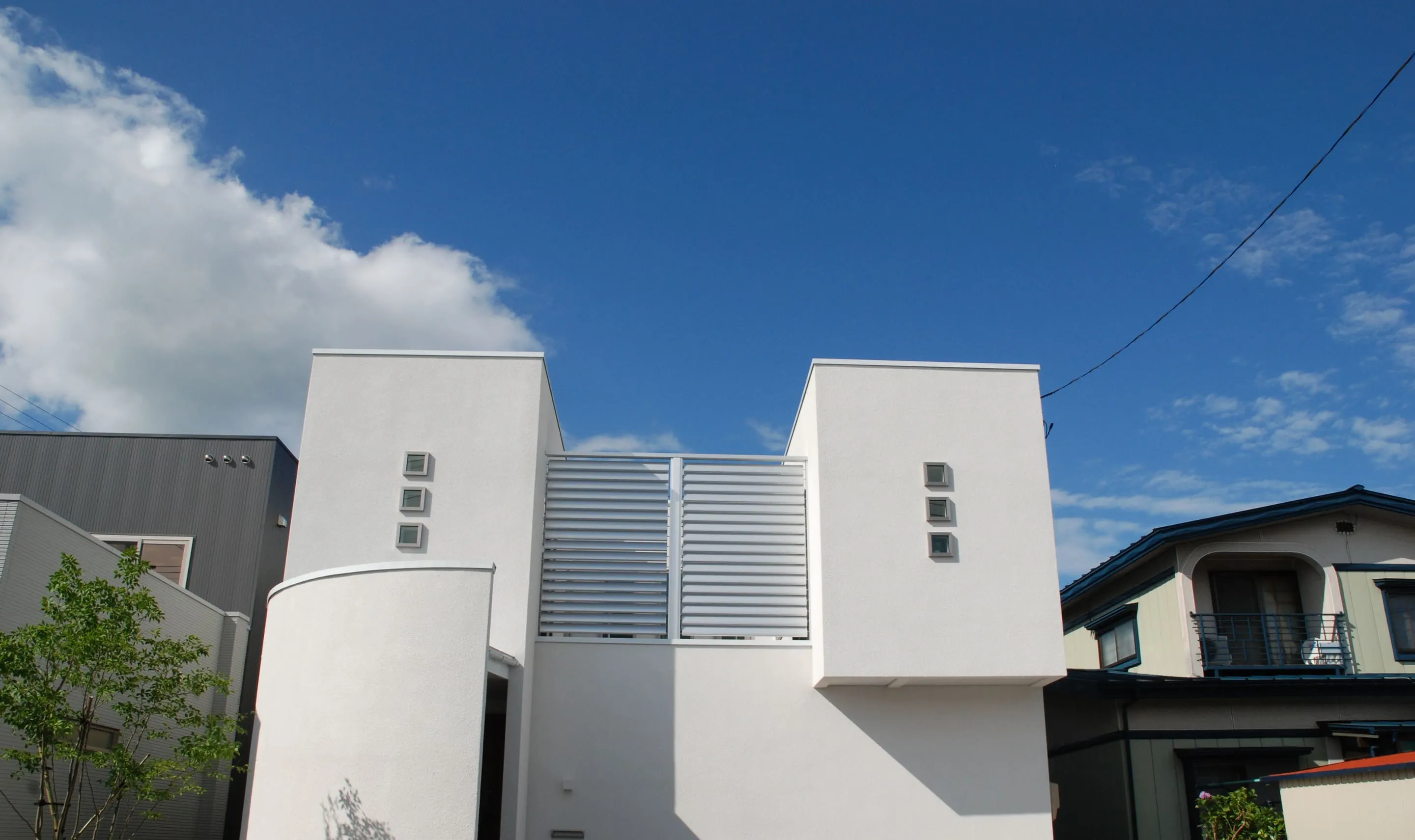 松園展示場の外観（白い外壁とルーバーの2階建て）